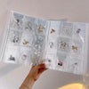A transparent jewelry organizer storage bag with multiple grids holding various pieces of silver and gold jewelry.