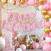 A pink and gold balloon arch decoration featuring foil letter balloons and stuffed animals for a birthday party.