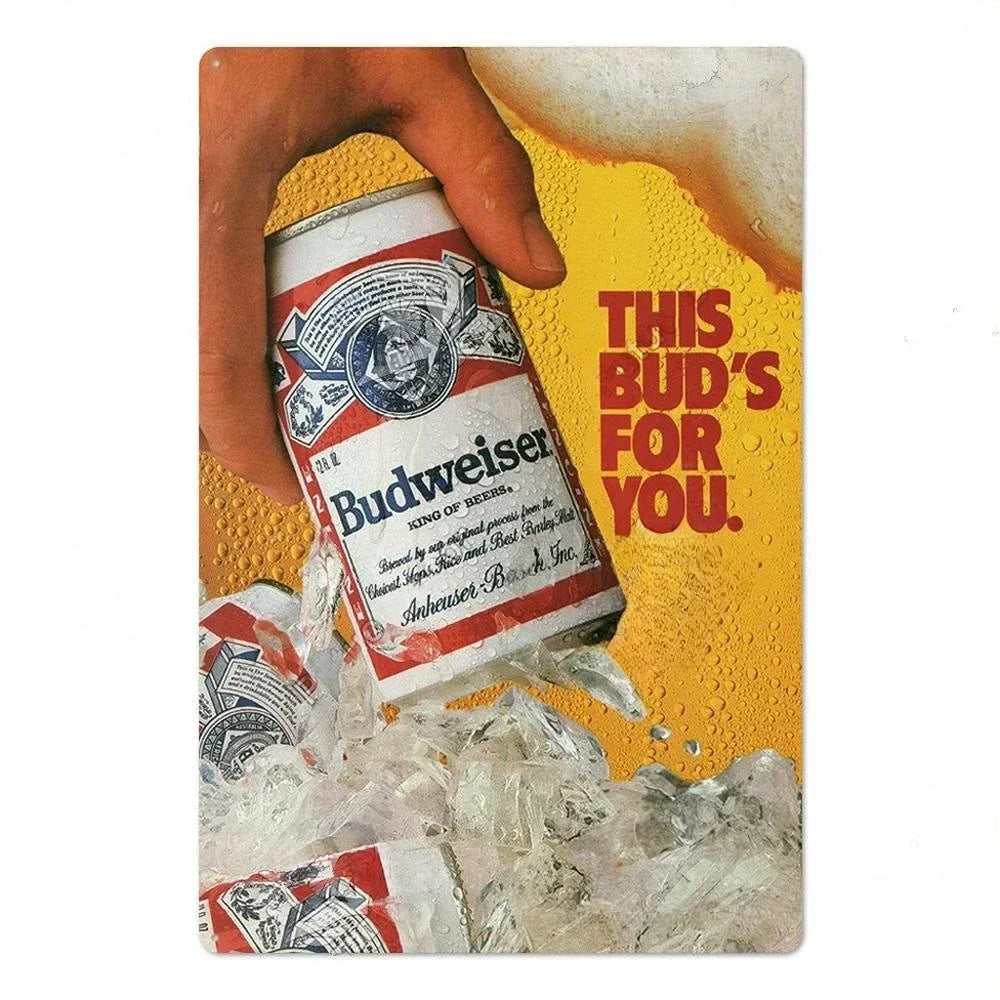 A hand is holding a can of Budweiser beer against a yellow background with ice and other beer cans.