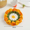 Hand-crocheted orange and white rose flower coasters displayed on a white surface.