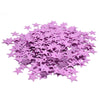 Une pile de confettis acryliques violets et argentés en laser scintillants.