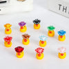 A collection of glow-in-the-dark resin duck figurines with colorful hats, including yellow, purple, black, green, and blue.