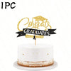A white cake with a gold topper that reads Congrats Graduates