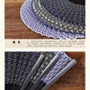A close-up of a dark blue titanium alloy folding hand fan with intricate patterns.