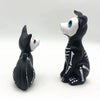 A resin figurine set featuring a black dog and a white cat, depicting Day of the Dead themes.