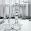 Elegant clear glass pillar candle holder with a flared base and pedestal design.
