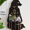 A black silhouette of a wolf howling under a starry moon holds various crystals and decor on a floating shelf.