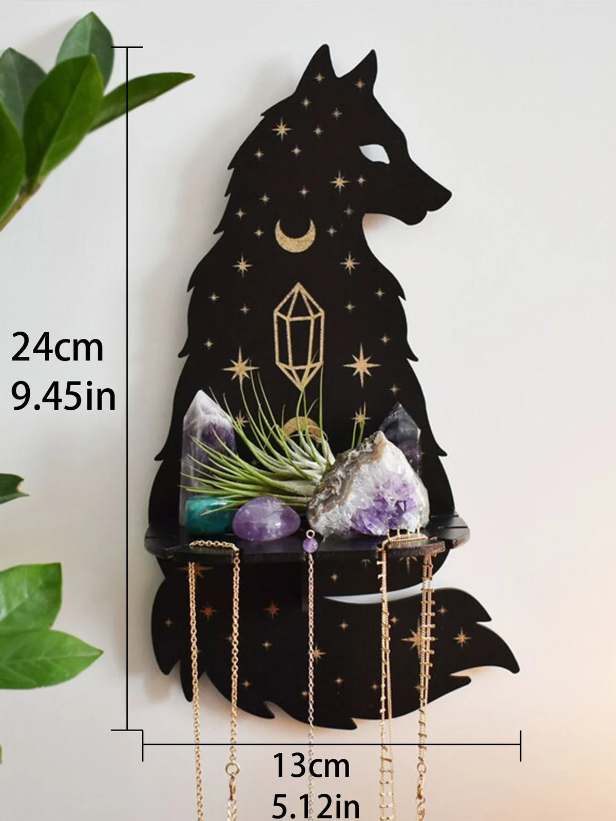 A black silhouette of a wolf howling under a starry moon holds various crystals and decor on a floating shelf.