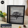 A black wooden photo frame displaying a grayscale silhouette of a tree against a misty landscape.