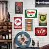 A collection of vintage metal tin signs and decor mounted on a white brick wall.