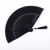A black traditional Chinese folding fan with a pleated design and decorative star patterns.