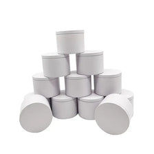 Un conjunto de latas de velas de metal blanco con tapas dispuestas en forma de pirámide.