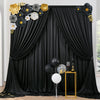 A black draped curtain backdrop decorated with gold and gray floral accents for parties and photography.