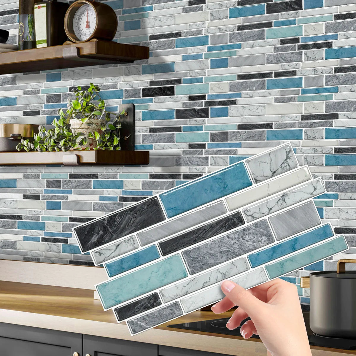 A hand holds a rectangular crystal film marble wall decal against a background of stacked gray and blue marble tiles.