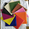A collection of colorful honeycomb beeswax candle DIY kits arranged on white paper.