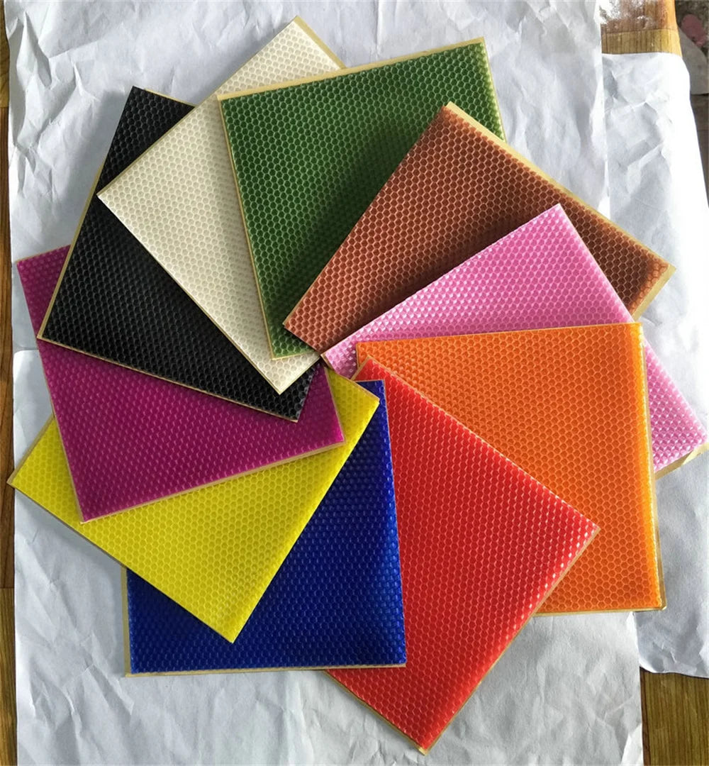 A collection of colorful honeycomb beeswax candle DIY kits arranged on white paper.