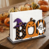 A wooden tissue dispenser featuring a black and orange ghost pattern with carved pumpkin designs.
