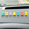 A set of six colorful kawaii anime fantasy creature mini figurines lined up on a car dashboard.