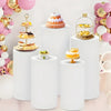White elastic cylinder stands used to display birthday cakes and party decorations