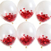 A collection of white balloons filled with red heart-shaped foil confetti.