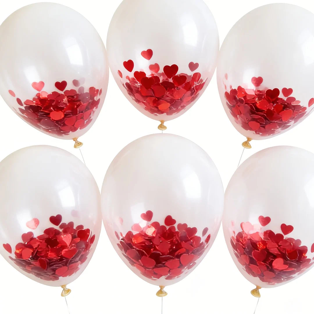 A collection of white balloons filled with red heart-shaped foil confetti.