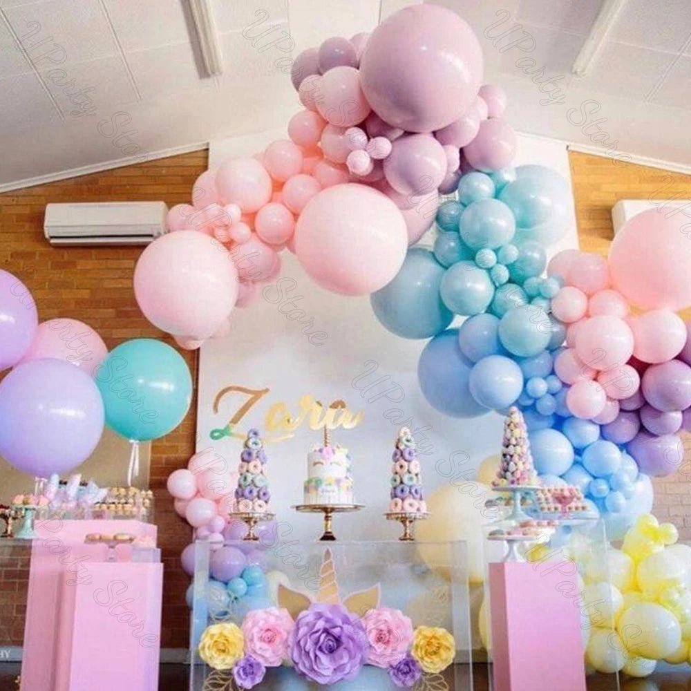 A colorful arrangement of pastel latex balloons in pink, purple, and blue for parties and celebrations.