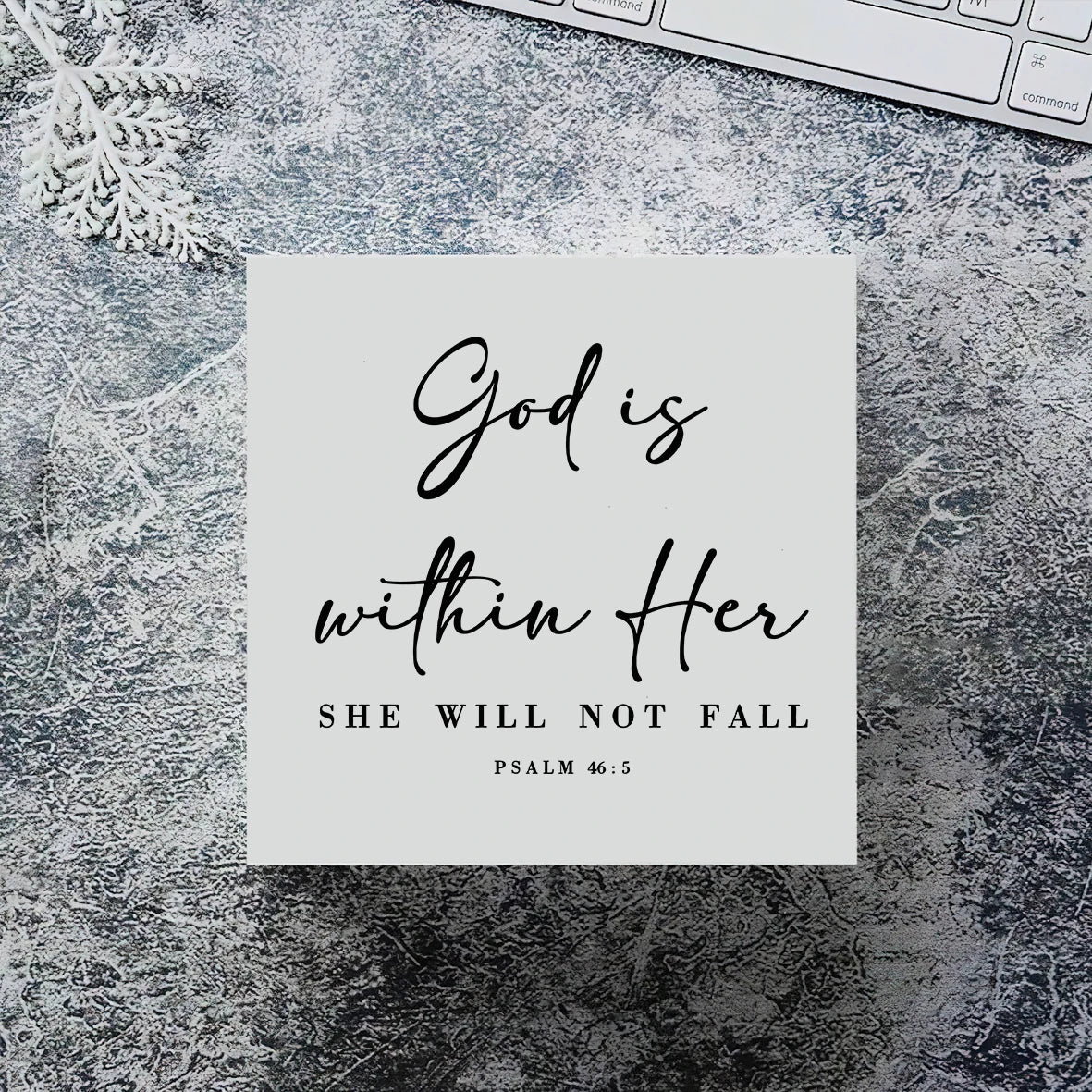 A white card with black script text reads God is within Her She will not fall Psalm 46:5 set against a textured gray backgrou