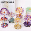 A collection of natural crystal trees featuring purple, yellow, and orange stones used for home decor.