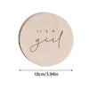 A round, light wood plaque with the cursive word girl engraved on it.