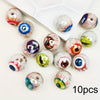 A collection of glossy, double-sided eyeball beads in various colors and patterns for crafting.