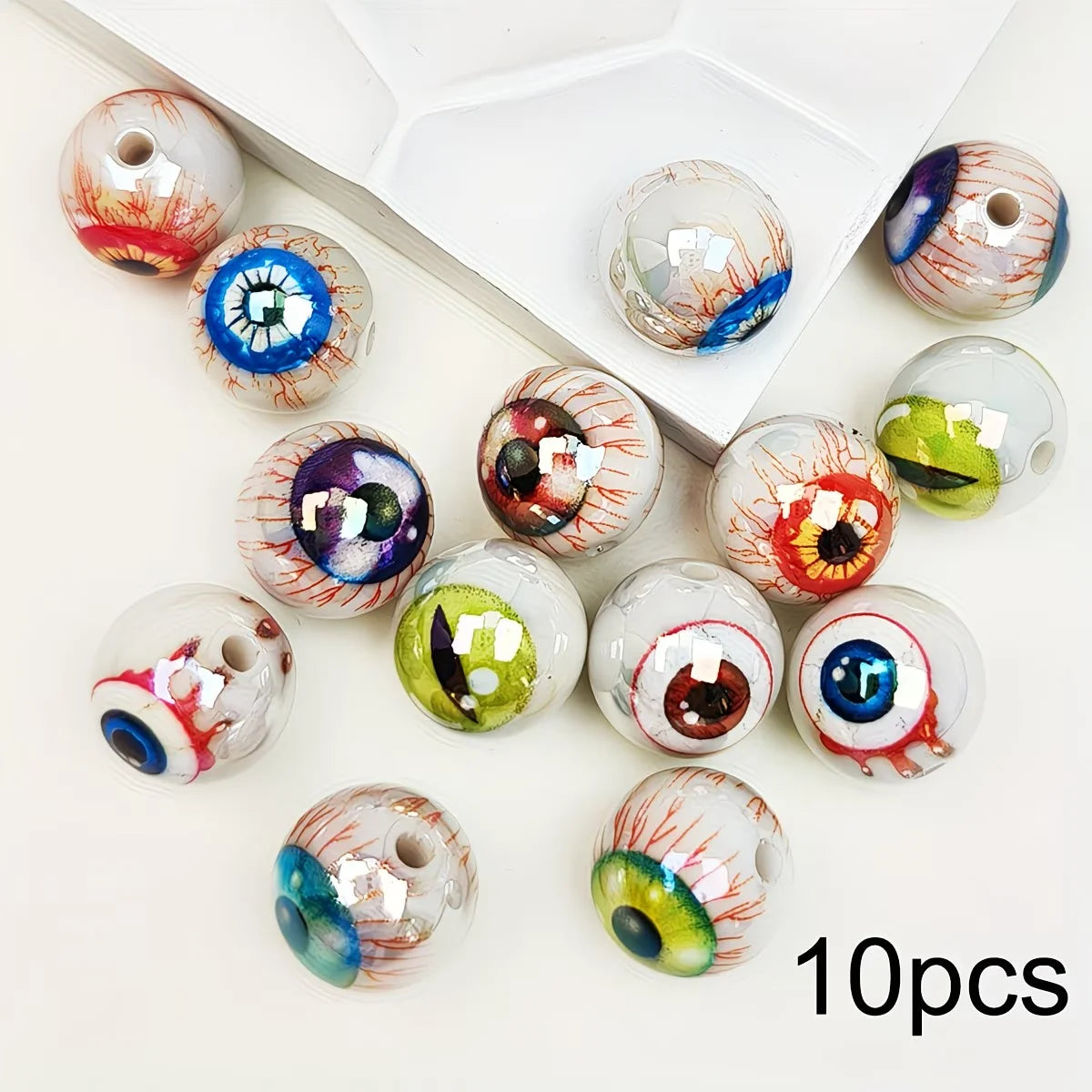 A collection of glossy, double-sided eyeball beads in various colors and patterns for crafting.