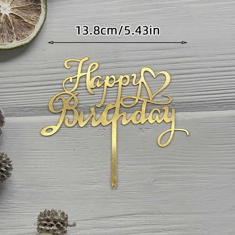 Gold acrylic birthday sign with a heart design on a wooden surface.