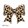 A bow-shaped balloon featuring a leopard print pattern in shades of black, brown, and tan.