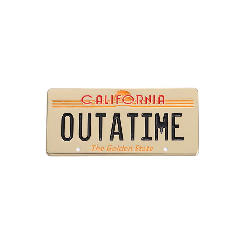 A rectangular gold license plate enamel pin featuring the text CALIFORNIA OUTATIME The Golden State