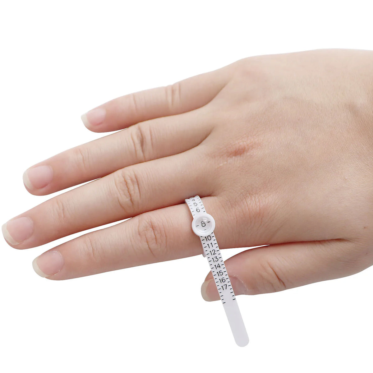 A hand holds an adjustable ring sizer with a built-in magnifier, showing the scale markings.