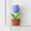 Handcrafted crochet blue tulip flower growing in a brown crocheted pot