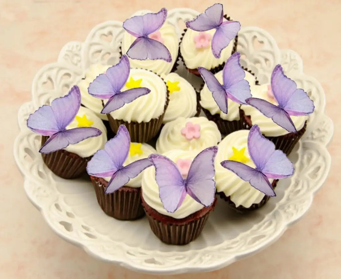 A plate of cupcakes decorated with purple butterfly toppers and white frosting.