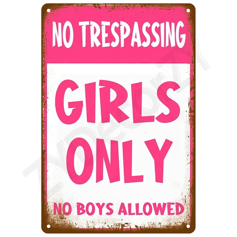 A pink vintage tin sign with white text that reads NO TRESPASSING GIRLS ONLY NO BOYS ALLOWED
