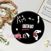 A set of black button pins featuring punk band imagery and text on a white background