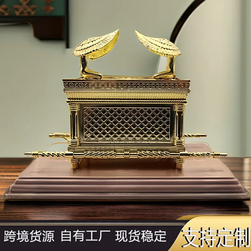 Gold metal statue of the Ark of the Covenant resting on a wooden base