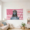 A tapestry wall hanging featuring an avatar-inspired Neytiri face against a pink and white striped patriotic flag background.