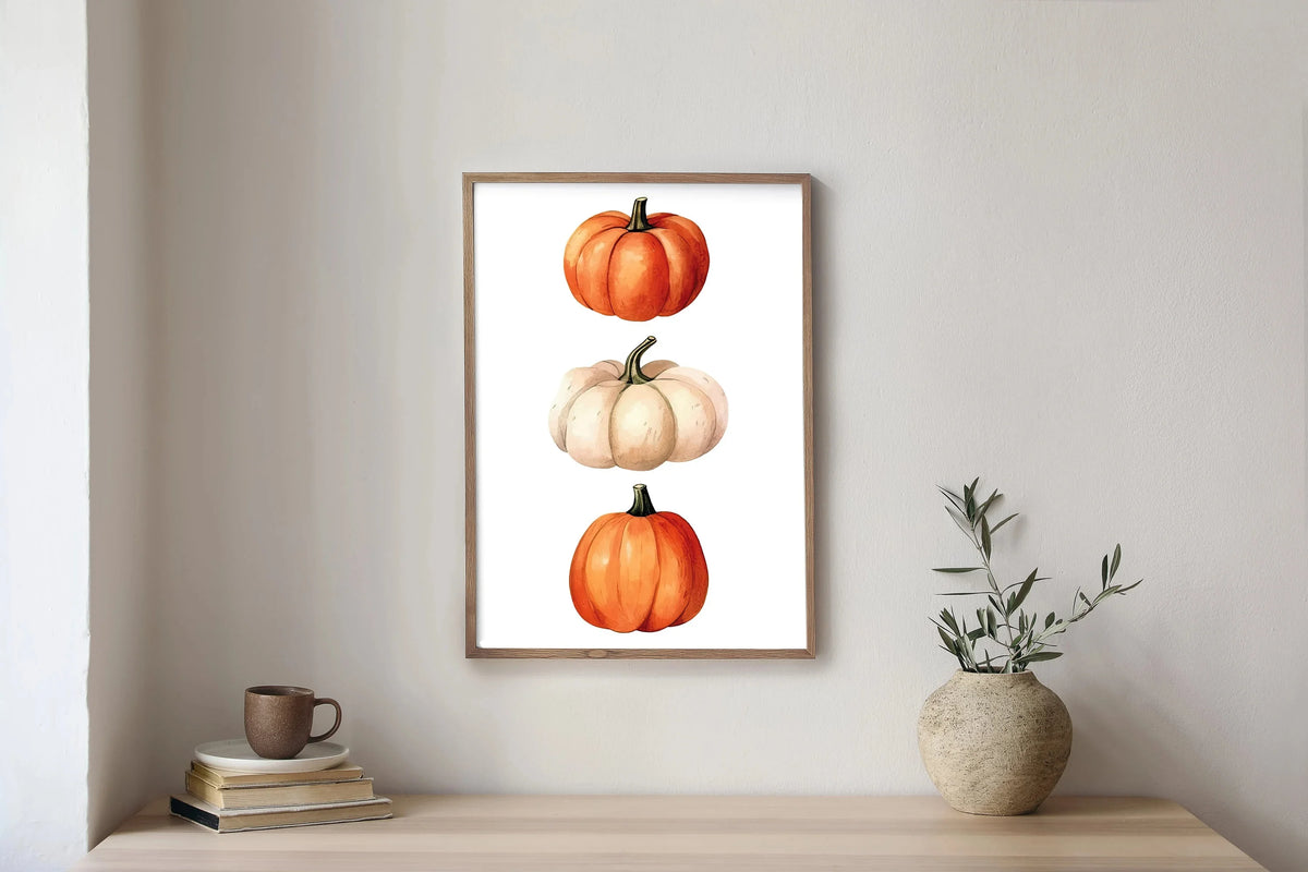 Wall art featuring three watercolor pumpkins in orange and cream tones framed in wood