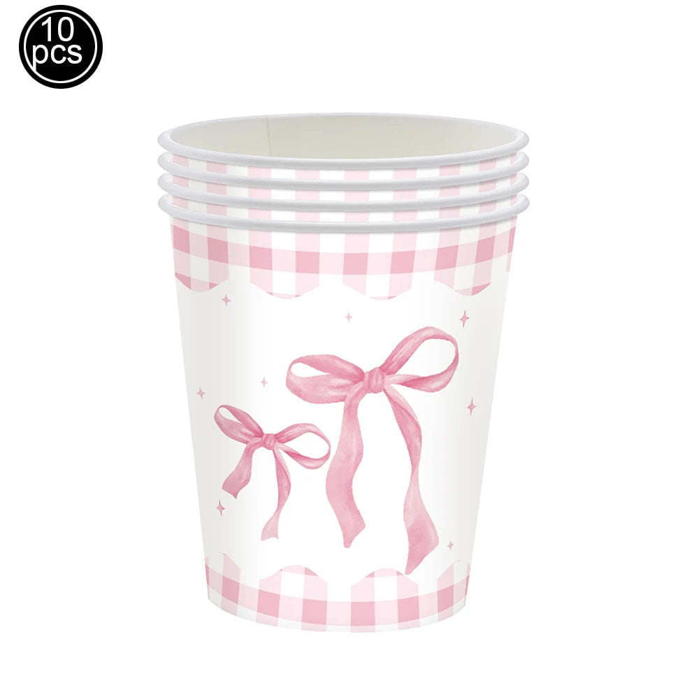 A clear plastic cup with a pink gingham pattern and a pink bow design for birthday party supplies.