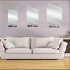 A white sofa is placed in front of a wall decorated with three silver-framed signs measuring 6x8, 8x12, and 12x16 inches.