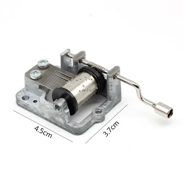 A silver metal music box mechanism with a wooden cylinder and a brass rod, shown against a white background.
