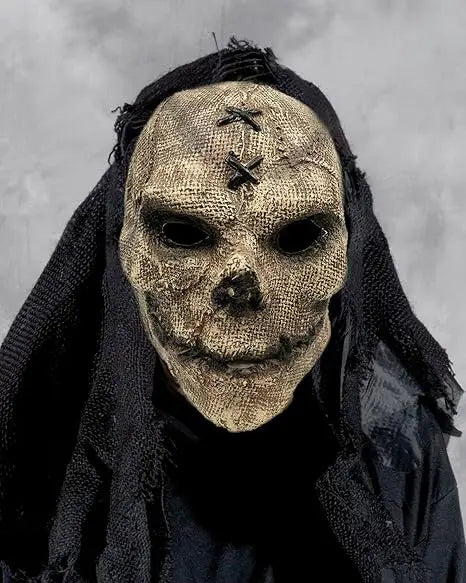 A realistic full-face latex mask resembling a skull with dark fabric draped over it.