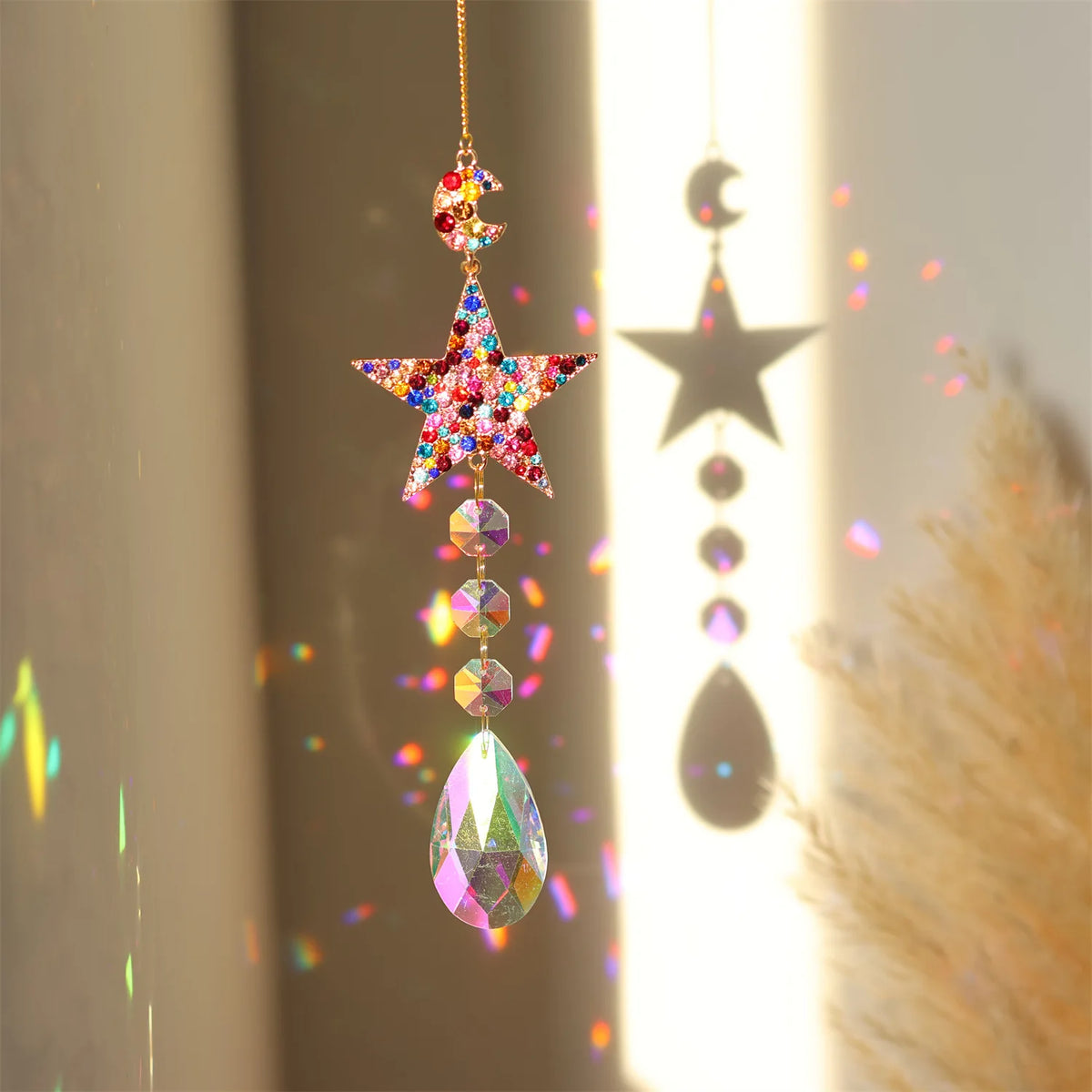 A hanging crystal sun and moon suncatcher with iridescent glass beads casting light patterns.