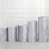 A row of four silver gray spandex cylinder stands used for event decor