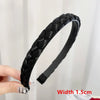 Black braided hair band with a black elastic strap shown on a hand.