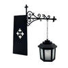 Black wrought iron lamp with a decorative scrollwork arm and a glass lantern shade